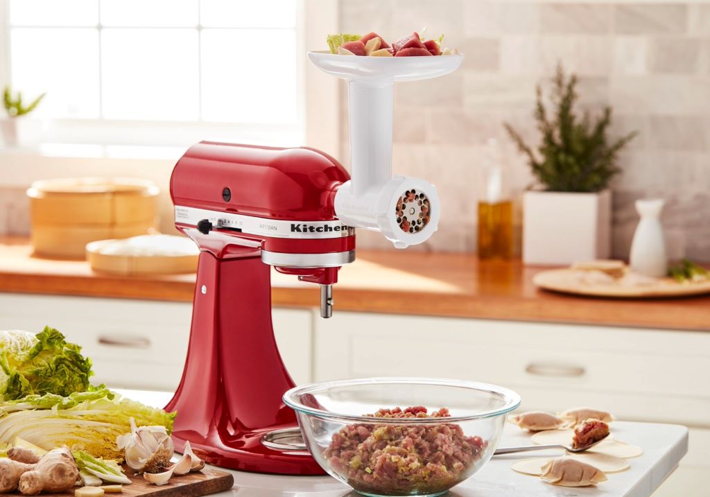 Close-up of KitchenAid KSMFGA Food Grinder in action.