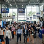 Visitors walking through an exhibition hall at a busy Miami business expo
